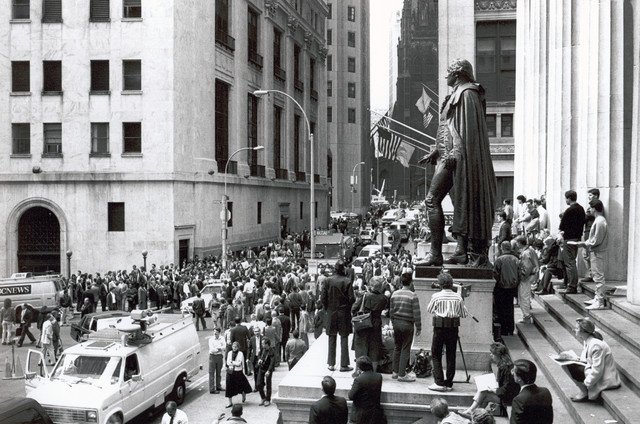 17/ Taking a seat high on the steps above Wall St, I watch the carnival below. Several news vans crowd into the narrow street, tires up on the sidewalk, antennas extended tall, reporters, cameras in chase, interviewing floor brokers and civilians alike. (I might be in this pic).