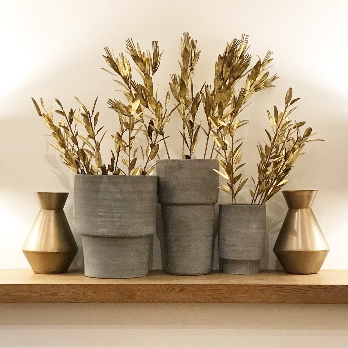 bagelandgriff's tweet photo. Grey cement pots displayed with gold metal foliage and pots. The metallic mood is in the shop! #shelfie #gold #grey https://t.co/2OfZjMl5DC