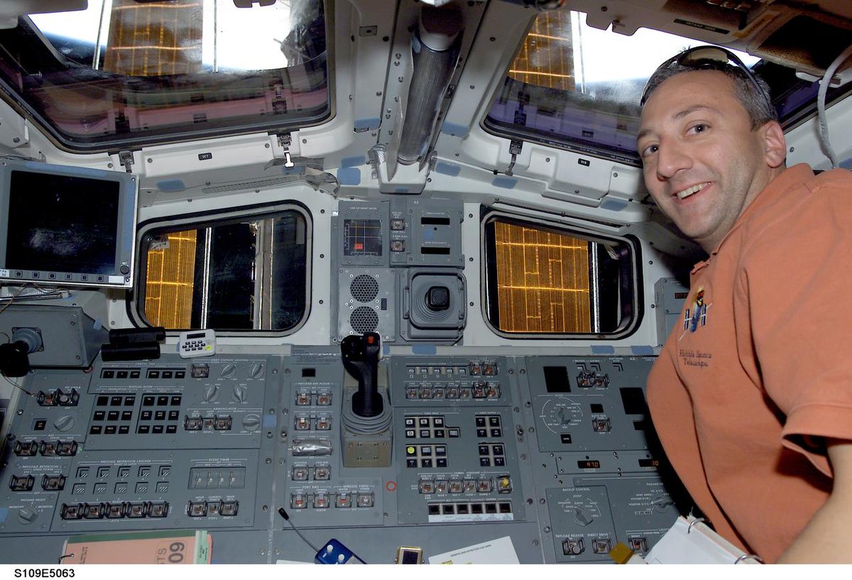 Astro_Mike's tweet photo. Here's a shot of me on Columbia's aft flight deck in '02, you can see a little of @NASAhubble thru the window #sts109 #tbt https://t.co/1NqH40uu1J