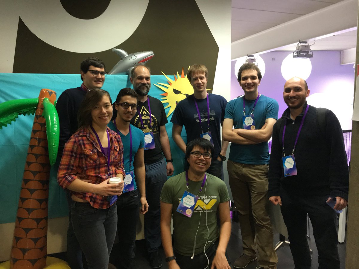 A group of people in front of a fake island background.