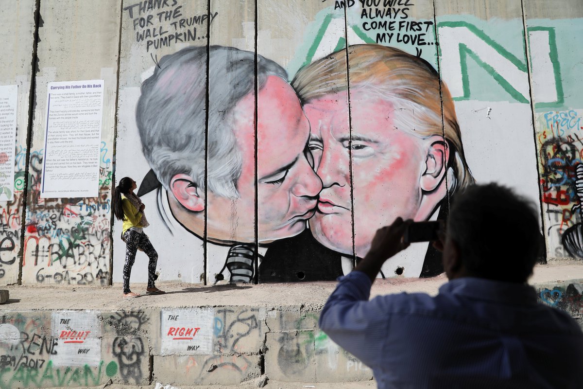 An artist painted Trump and Israeli PM Netanyahu on Bethlehem's border wall in protest of Palestinians being stuck in an "indoor prison."