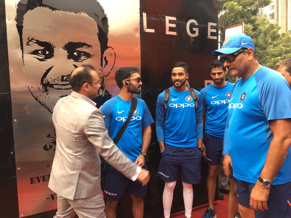 BCCI's tweet photo. Head Coach @RaviShastriOfc and #TeamIndia members congratulate @virendersehwag after the gate at Feroz Shah Kotla was named after him. https://t.co/bveVvQtUrP