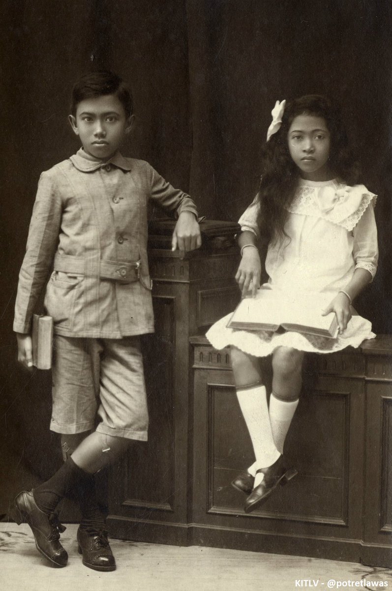 Dua bocah Jawa, 1920. Pakaian barat, buku, &amp; bertelekan tangan adl gaya berfoto umum kalangan atas sejak abad 19.