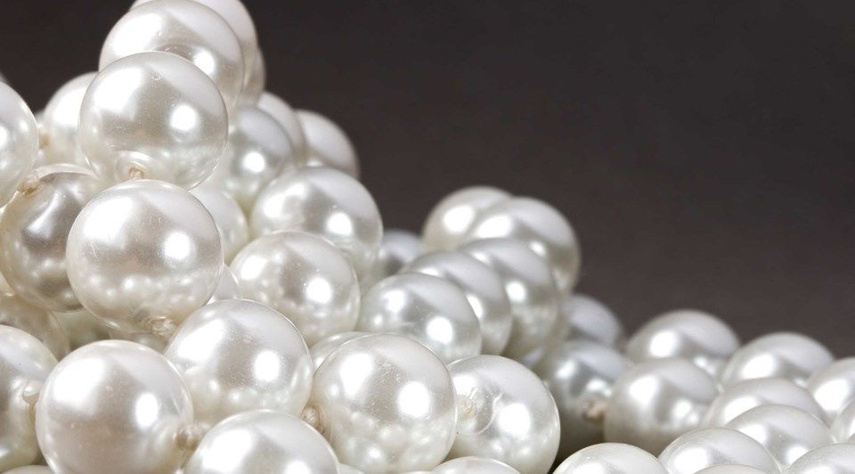 жемчужные бусы на столе. чёрная и белая жемчужины. черно белый жемчуг. жемчуг на ткани. черный жемчуг эстетика.