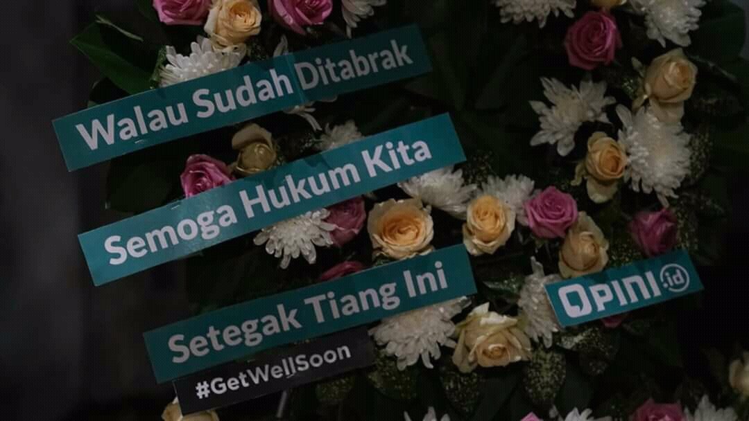 Tulisan dalam karangan bunga untuk tiang listrik