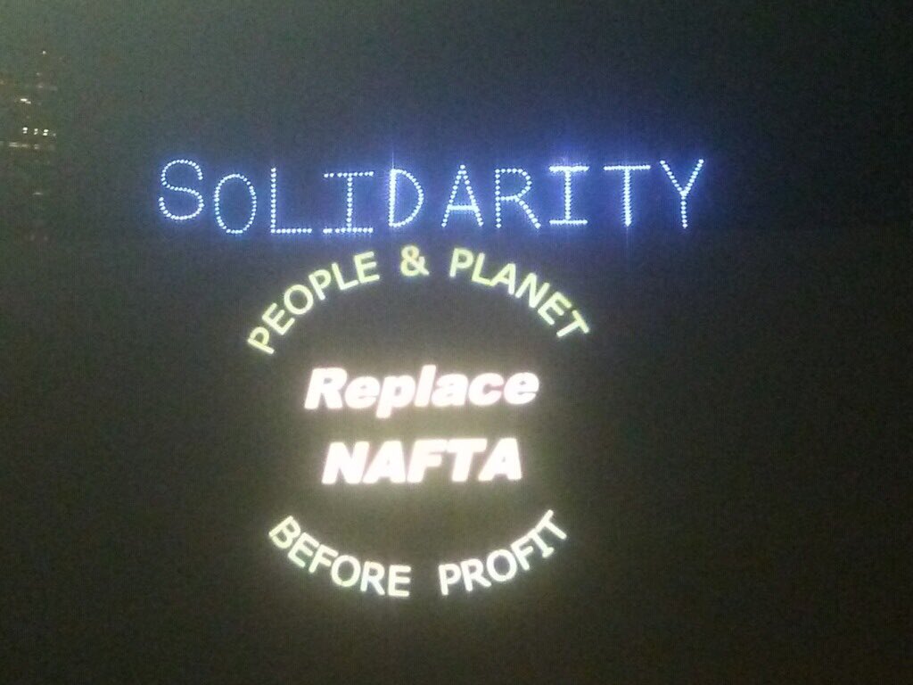 ORFTC's tweet photo. Projecting and light-brigading in downtown Portland.  Intercontinental Day of Action Against Free Trade and Neoliberalism. #ReplaceNAFTA https://t.co/3kWntACNzT