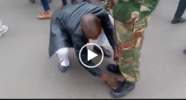NehandaTV's tweet photo. WATCH as protester polishes soldier's boots during anti-Mugabe protest in #Zimbabwe - https://t.co/aJkOsIQrct https://t.co/AHMpUugbYu