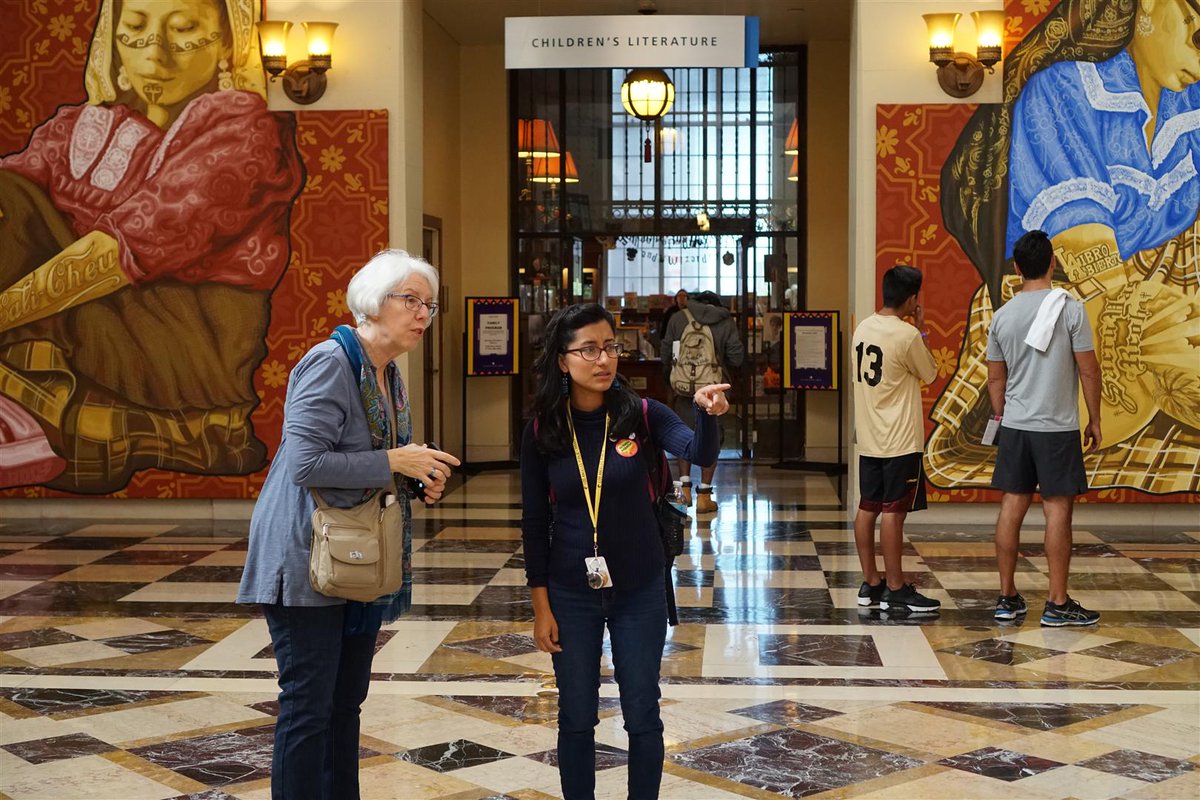 young lady pointing to piece in Visualizing Language exhibit