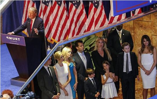 (3) The Trump family listens to his campaign launch speech while he is reflected in the side of the elevator itself.