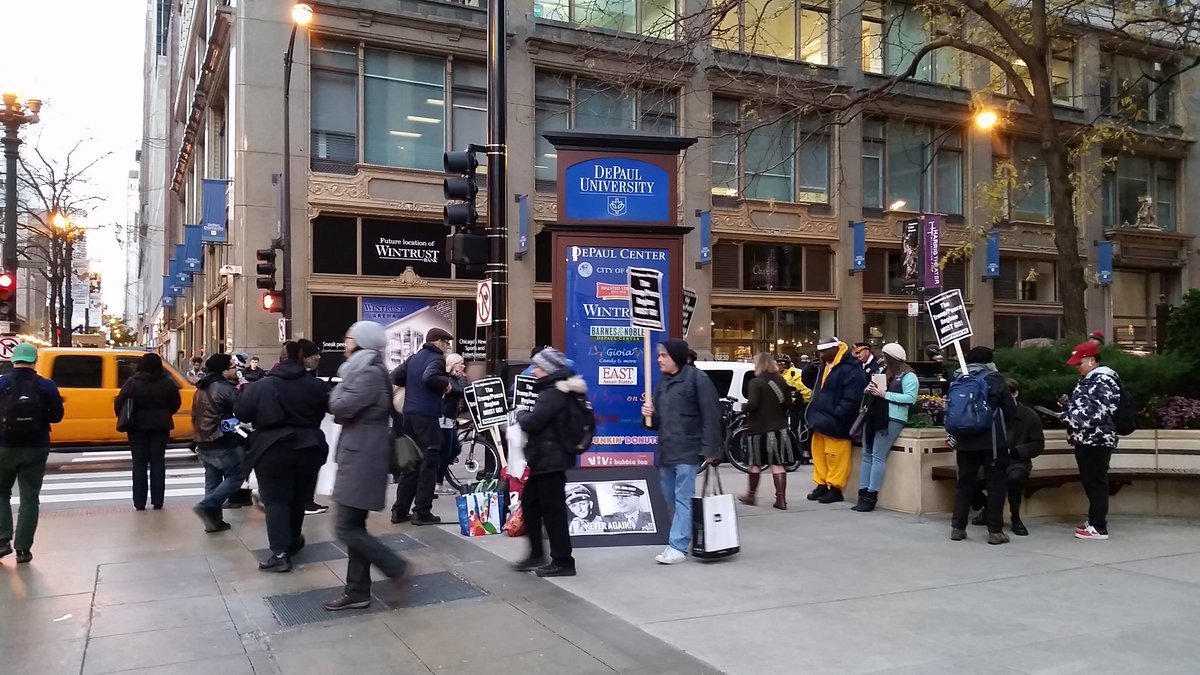 "Trump/Pence regime MUST GO!"  20 pers marcherar runt en skylt. Ett år sedan valet men motståndet står fortsatt starkt...