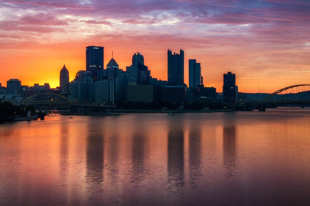 DaveDiCello's tweet photo. A warm glow radiates from the horizon where the sun would eventually rise behind #Pittsburgh as vibrant colors fill the sky above the city https://t.co/rhg3V9zxfG
