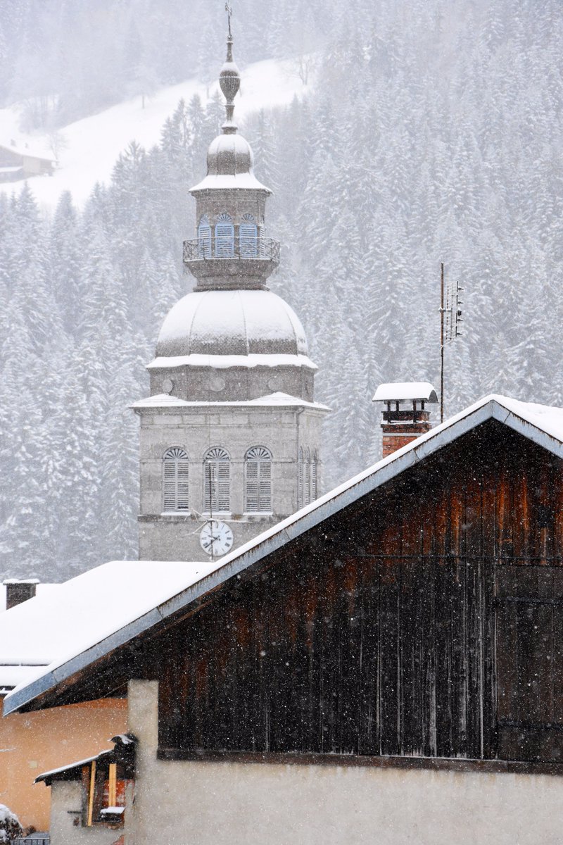 Breaking news ➡️ La neige est de retour au Grand-Bornand ! Le clocher, les chalets, les sapins, les boîtes aux lettres, les terrasses ... tout est blanc 🌨