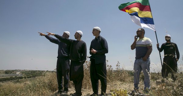 Members of the Druze community watch the fighting in Syria's civil war, next to the border fence between Syria and the Israeli-occupied Golan Heights, near the Druze village of Majdal Shams, Credit: Baz Ratner/Reuters