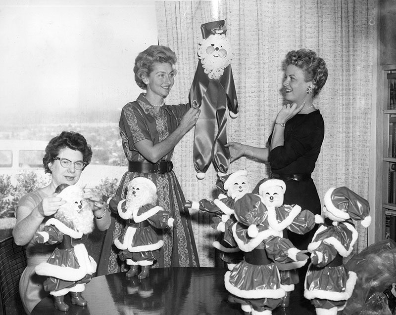 Photograph caption dated December 3, 1959 reads, "Mmes. Frank R. Sullivan, Donald Blanchard and Ralph Miller, from left, put finishing touches on cluster of Santas.