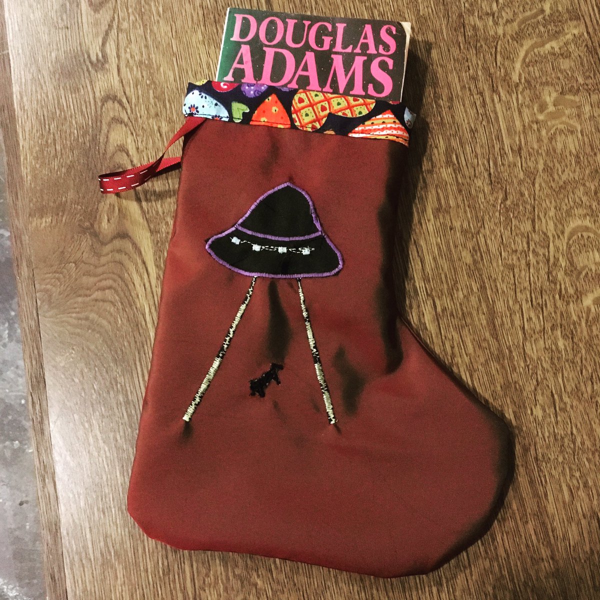 BorderBookshop's tweet photo. Book-size stocking with UFO abducting a tiny cow blob. Inspired by one of our customers. Handmade £5 each https://t.co/psjbsurOXt