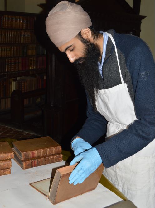 mertonlib's tweet photo. This is Jaz from the Conservation Consortium removing dust from books in the Upper Library today. He uses a smoke sponge and a special, lightweight conservation vacuum cleaner. https://t.co/LtX0CovYpQ