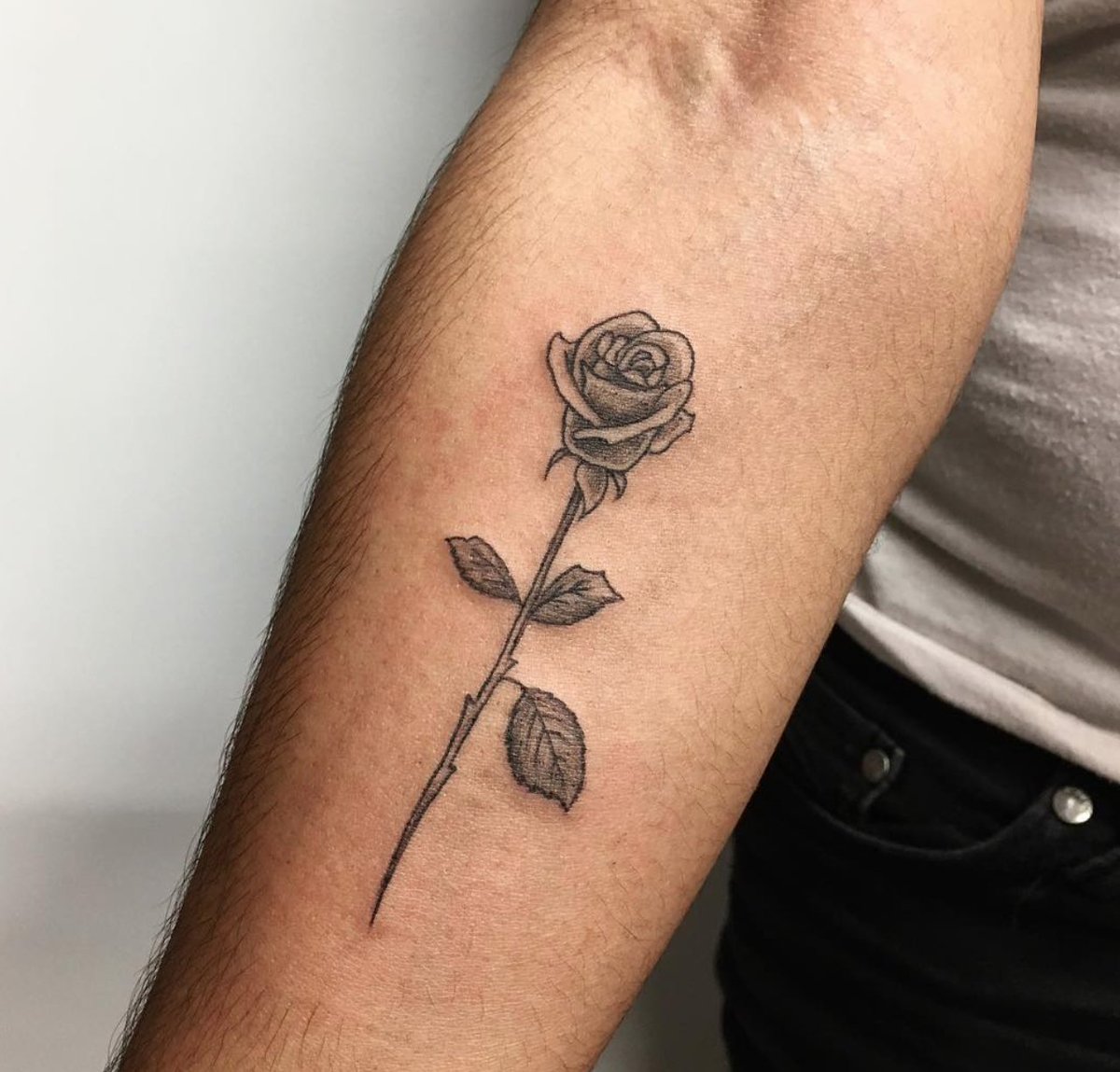 There's so much beauty in this delicate rose tattoo by Winston.