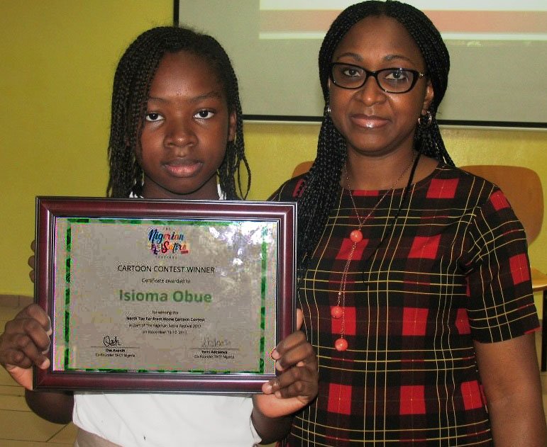 TCISABUJA's tweet photo. @FMENigeria @UNESCO @NGRPresident @trcollegeabuja @CNNAfrica Winner of The Nigerian Satire Festival Cartoon Contest, Isioma Obue (Grade 5) displays her award next to TCIS Proprietress, Mrs. Orumenosen Omoluwa. The contest focused on the humanitarian crisis in North-East Nigeria. https://t.co/wHoSMxb9UY