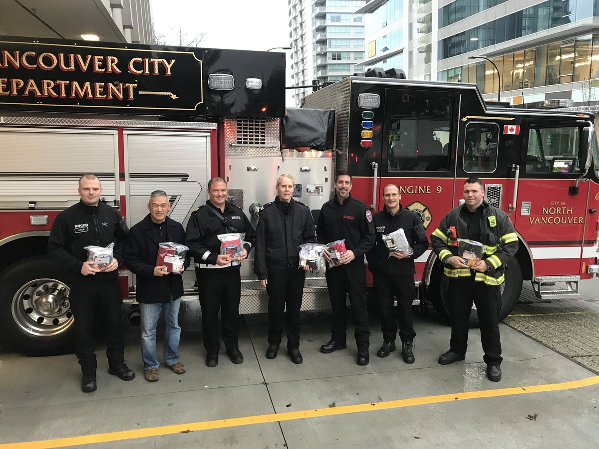 NVCFD's tweet photo. NVCFD crews pose with Cpl. Randy Wong from the NV RCMP with warming kits for the homeless which all NVCFD fire apparatus will be carrying https://t.co/xDO3OH2OiH
