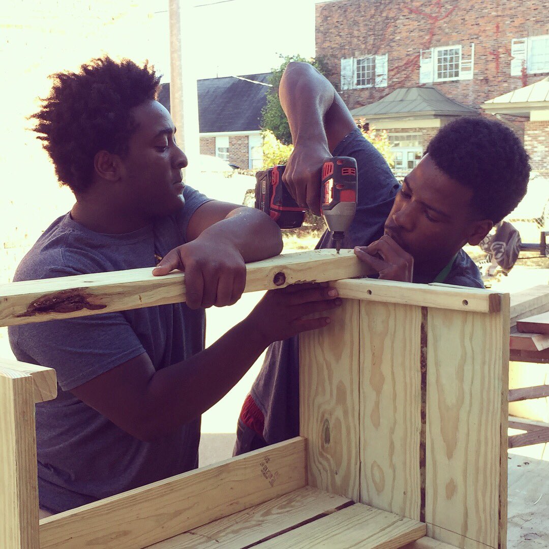 delta_d_b's tweet photo. Dontavius and BJ are working hard at the workshop on our benches that we will have available for sale at the @ArtPlaceMS Marketplace next Saturday. Most of the material comes from salvage or leftover job-site scraps #deltadb https://t.co/b386FU7cD5