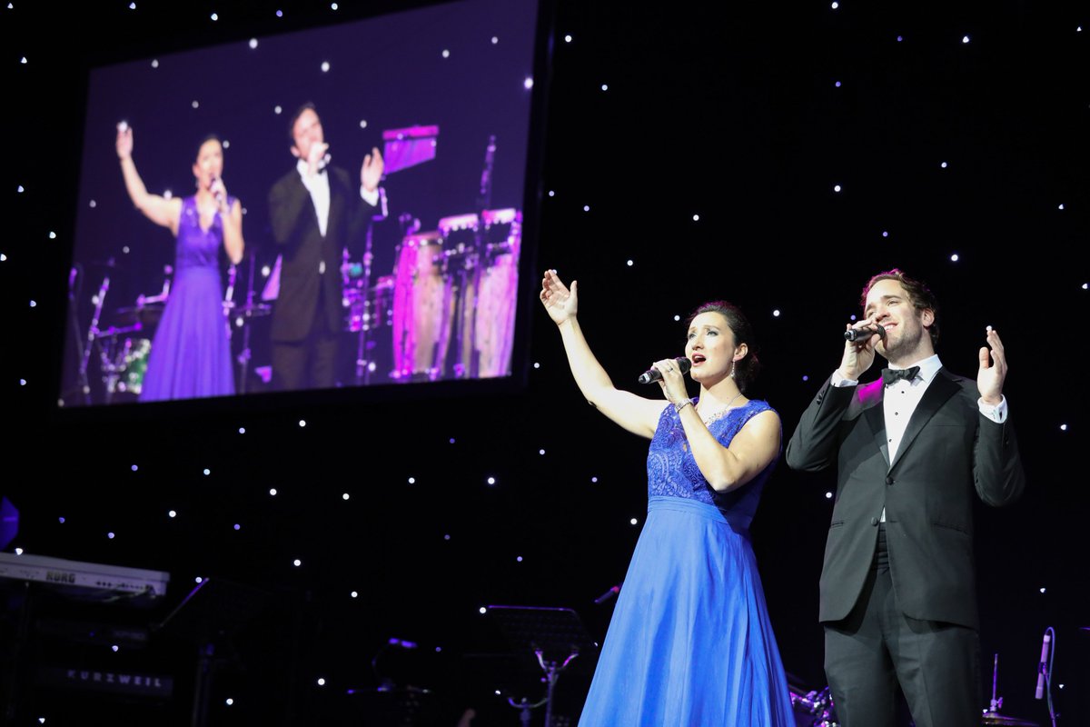 CwC_UK's tweet photo. The talented @SairaSopranoUK and @RobinBailey01 performing for our #CWCBALL guests on Saturday 11th November. Thank you for entertaining us on a night we raised over £600,000 towards supporting children with cancer so they can be with their families for longer. https://t.co/P7WFyhq0Sk