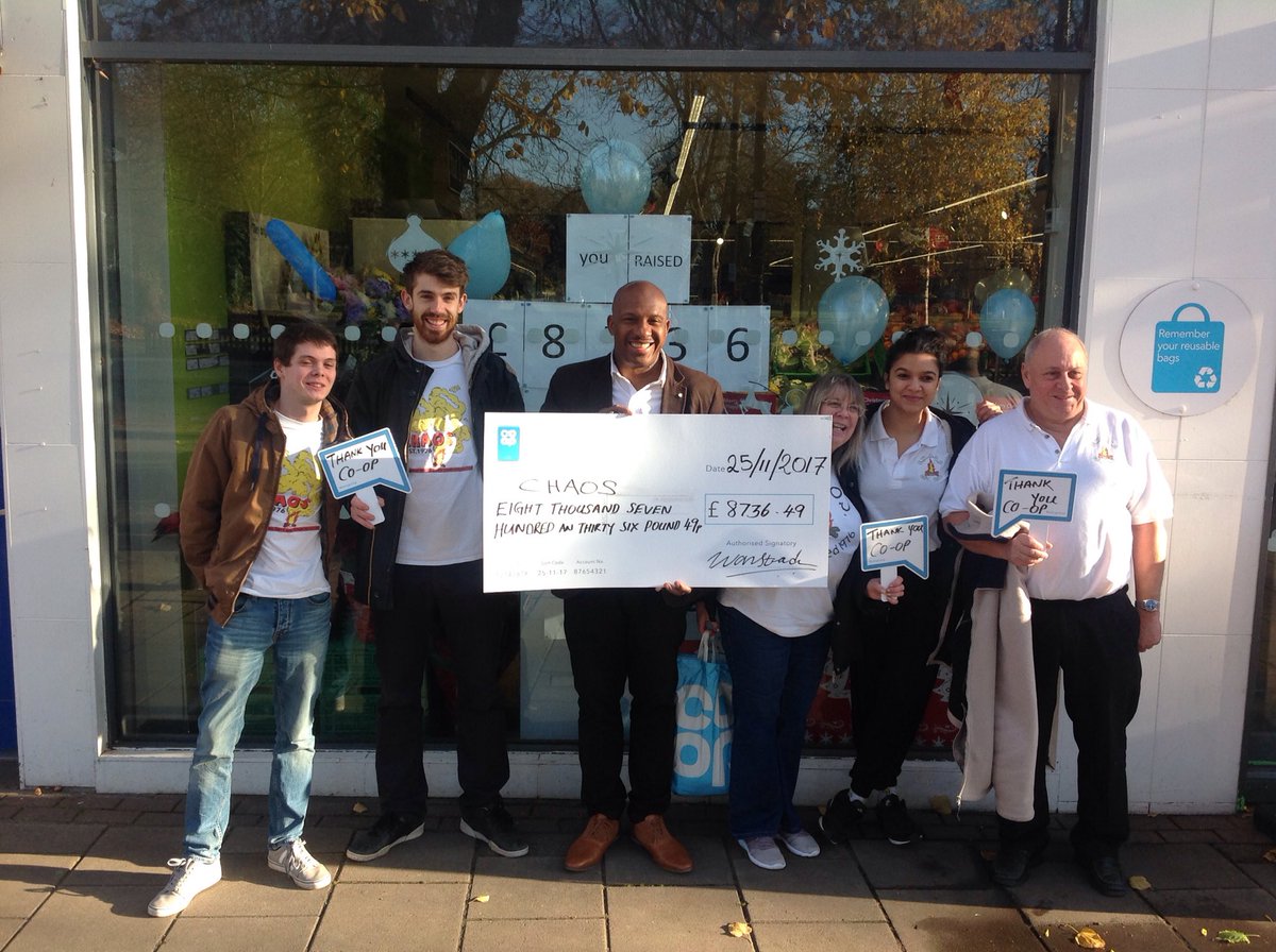 Coop Wanstead celebrating with a share of the £20m , with Chaos a local charity who received a check for £8736. 49 .