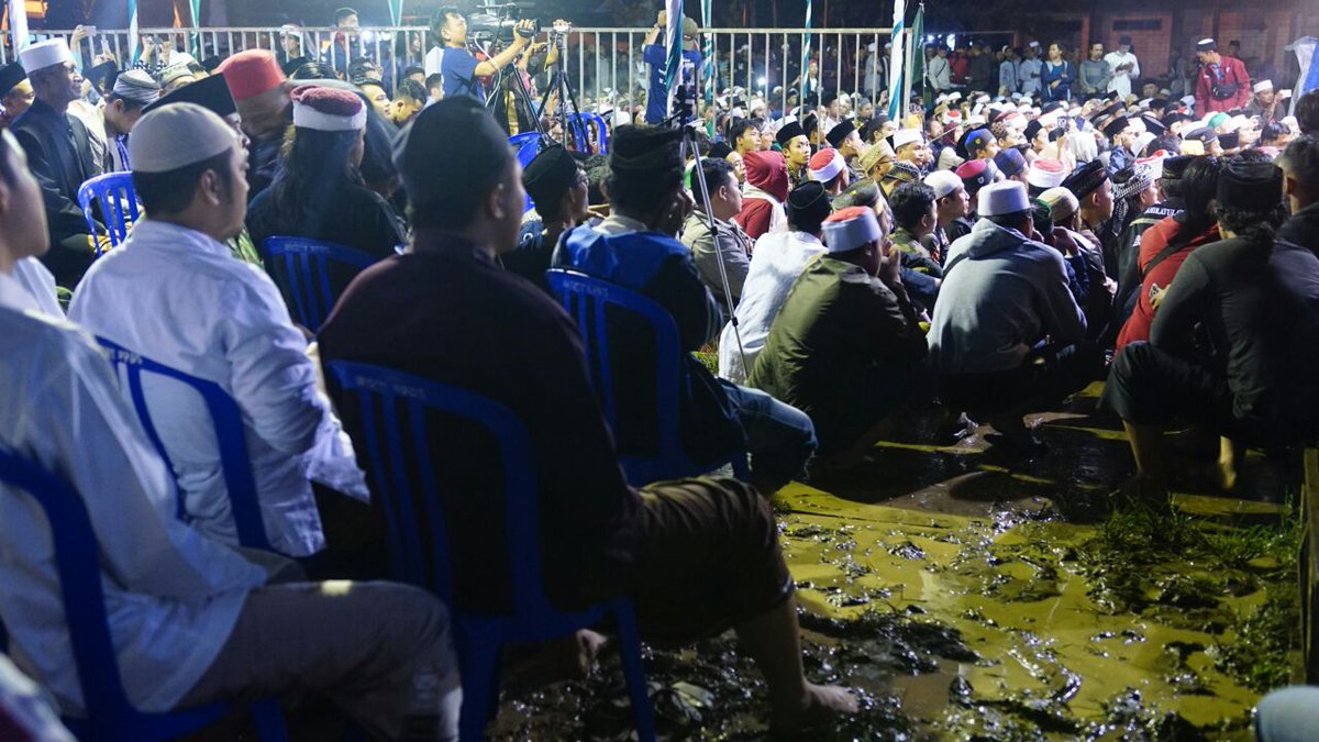 kiaikanjeng's tweet photo. Hujan yang mengguyur Banyuwangi membuat lokasi #MaiyahBanyuwangi menjadi berair dan berlumpur. Namun tak mengurangi masyarakat untuk mengikuti Sinau bareng Cak Nun dan KiaiKanjeng. (26/11) https://t.co/TSHr8eQ6aJ
