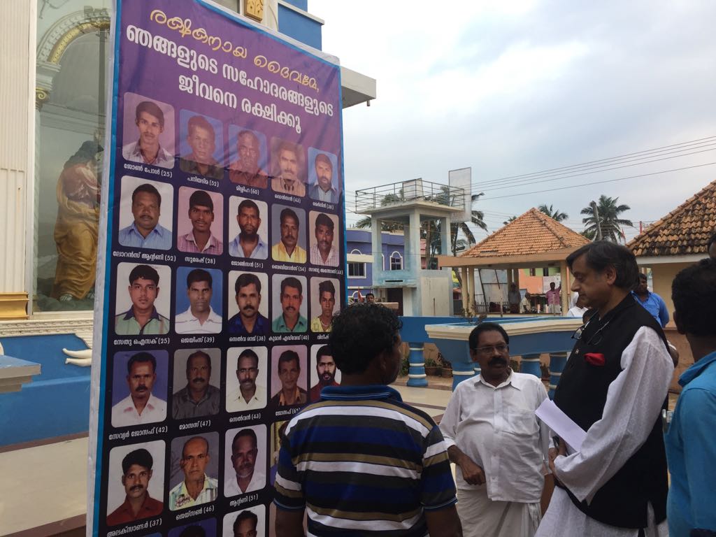 ShashiTharoor's tweet photo. Emotional visit to the coastal village of Poonthura which has suffered painfully in #CycloneOckhi. Banner shows names &amp;pix of 26 fishermen still missing including 15 year old Vinish. The grief of wives&amp;mothers was unbearable https://t.co/g21Vb99Z97