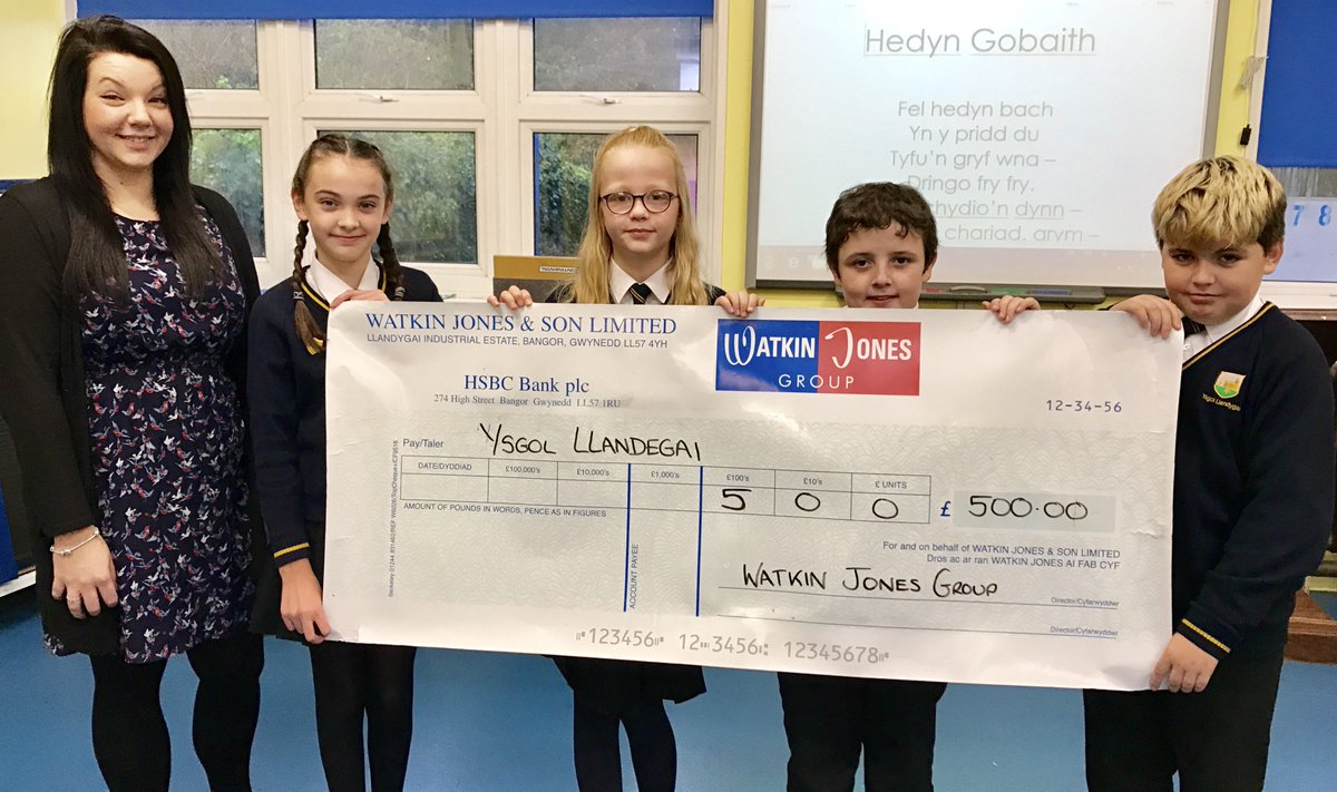 Llun o'r Prif ddisgyblion yn derbyn siec o £500 gan Watkin Jones fel rhodd i'n cefnogi i ddatblygu'r ardal tu allan. Diolch yn fawr iawn!