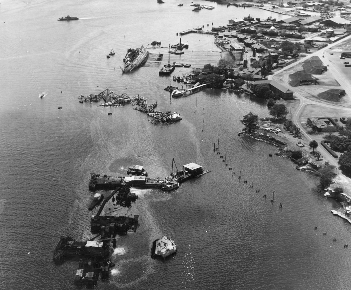 May 1943: Aerial view of Battleship Row with the righting of the USS Oklahoma in the distance and the sunken USS Arizona in the foreground. Ford Island is at right. Thank you to Dan Brown for sharing.