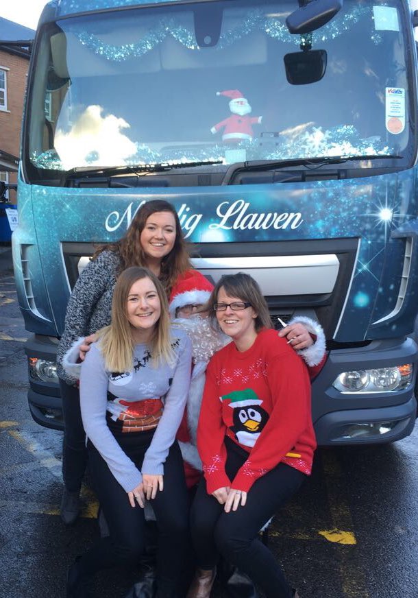 Tîm Cymraeg <a href="/BIHywelDda/">BIP Hywel Dda</a> yn ein siwmperi Nadolig o flaen lori #CHSANTA <a href="/castellhowell/">Castell Howell Foods</a> i ddathlu #DiwrnodSiwmperNadolig | 
<a href="/HywelDdaHB/">Hywel Dda UHB</a> WL team with the Castell Howell xmas lorry to celebrate #ChristmasJumperDay