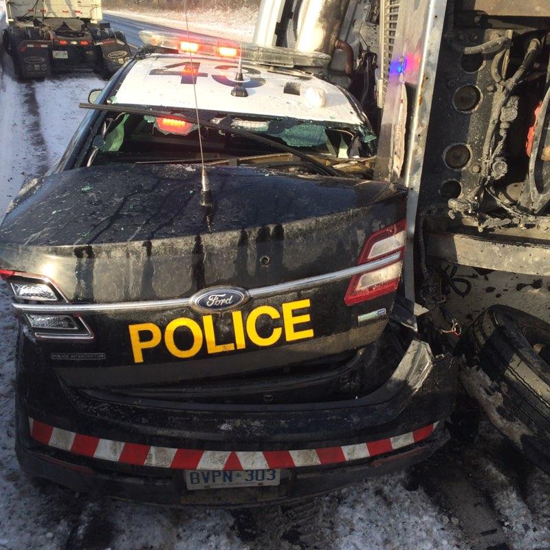 OPPCommissioner's tweet photo. #OPP cruiser on side of #Hwy401 struck by loaded car carrier that lost control, sending a loose vehicle to land on hood of cruiser with officer inside. Very lucky officer not injured.

#ThankYou to our members doing dangerous work every day.

Please #SlowDownMoveOver #CMVSafety https://t.co/NKSZVD7L5x