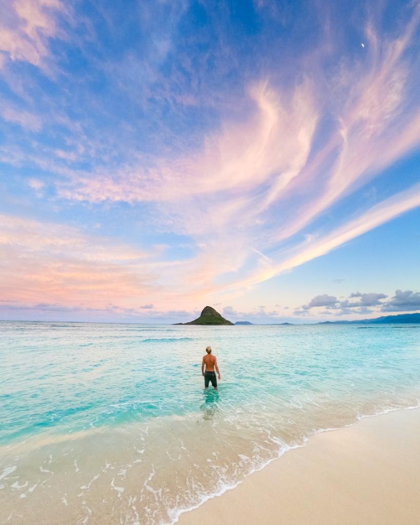 GoPro's tweet photo. Who's escaping to somewhere warm for the holidays? 🌴 After #paddleboarding to a small island off of #Oahu, @TravisBPhoto captured a colorful sunset while @cobiandewey watched the clouds dance around an illuminated moon. 🌙 https://t.co/CqBhL8wOIW