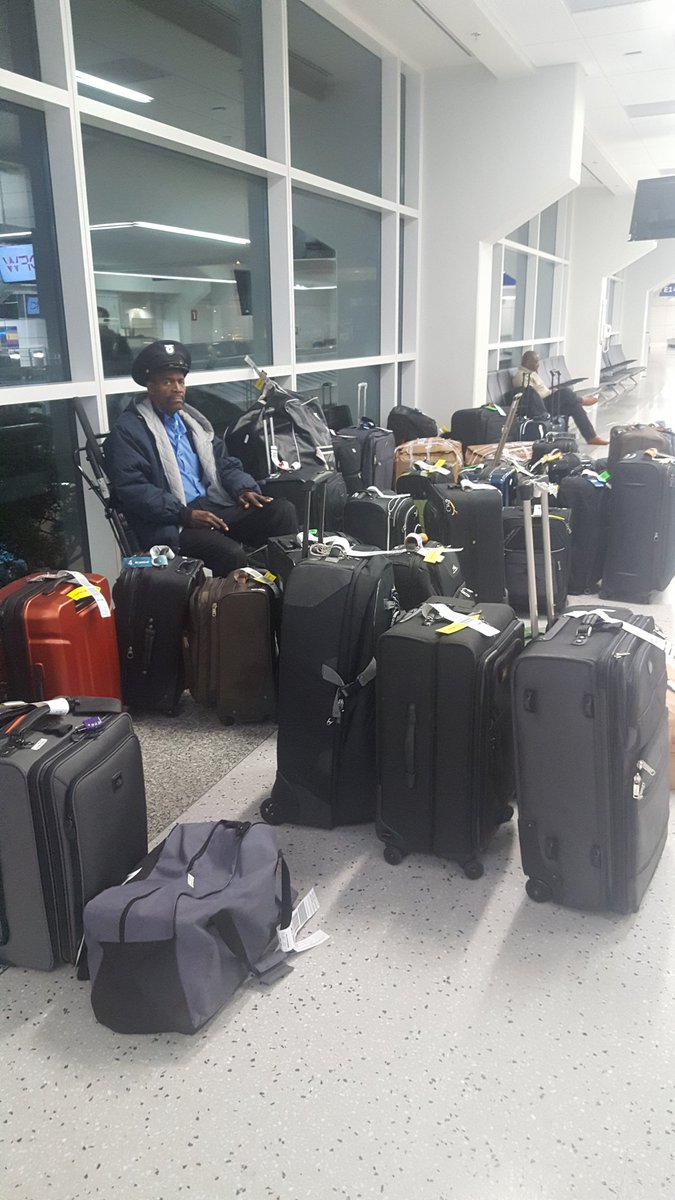KristinWeisTX's tweet photo. This man has an important job today: guard the luggage that didn't make it to Atlanta. Somehow it ended up here at @DFWAirport! #AtlPowerOutage @KRLD https://t.co/8wTzbrb2Uz