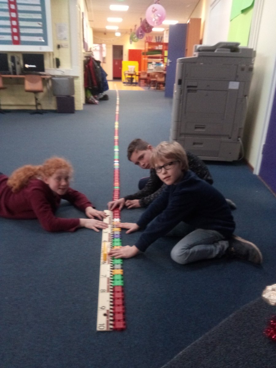 Jurjen, Nynke en Erik meten een Knex slang: hij is 16,6 meter, 166 decimeter, 1660 centimeter en 16600 millimeter!