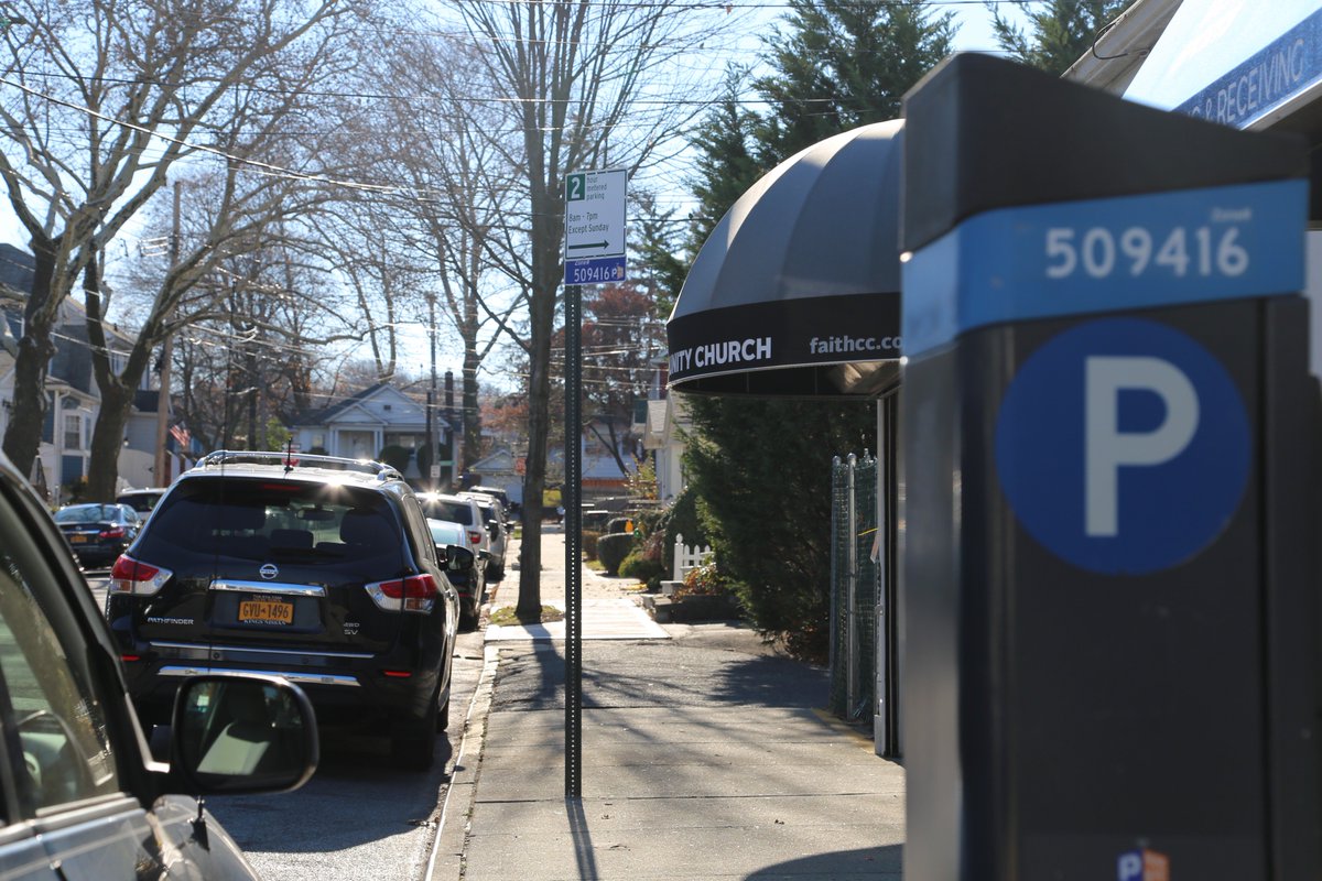 A street in Staten Island with a Park NYC sign on a meter and sign pole.
