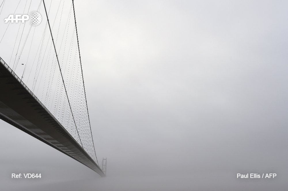 AFP's tweet photo. Into the mist: the Humber bridge near Hull in northeast England is enveloped in a low-hanging cloud https://t.co/z5Y282d7c3