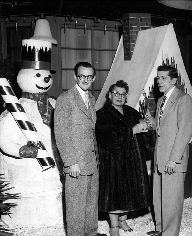 people standing next to snowman