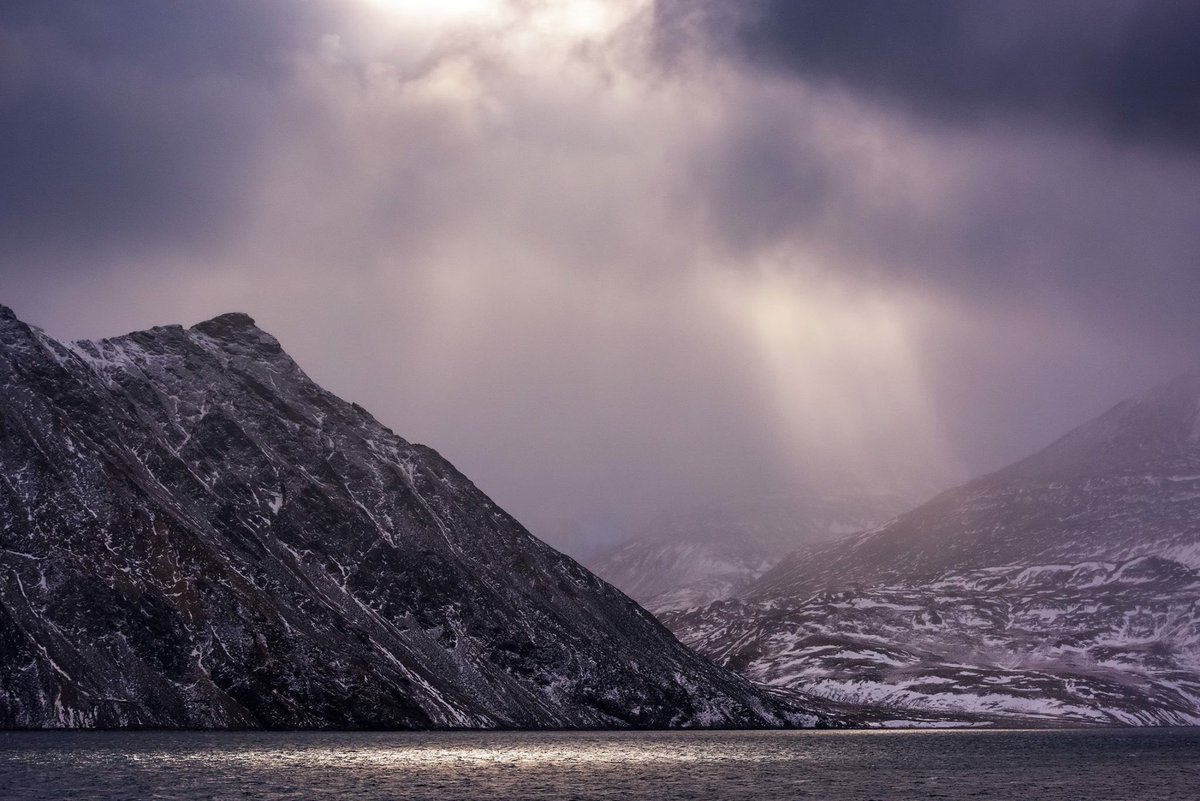 Photography helps interesting light shine. Here sunlight breaks through an autumn storm along the eastern coastline of #Baffin #Island. No matter what the weather conditions are these #fjords along Baffin Bay are exceptionally beautiful in their ruggedness.<a href="/ParksCanada/">Parks Canada</a>