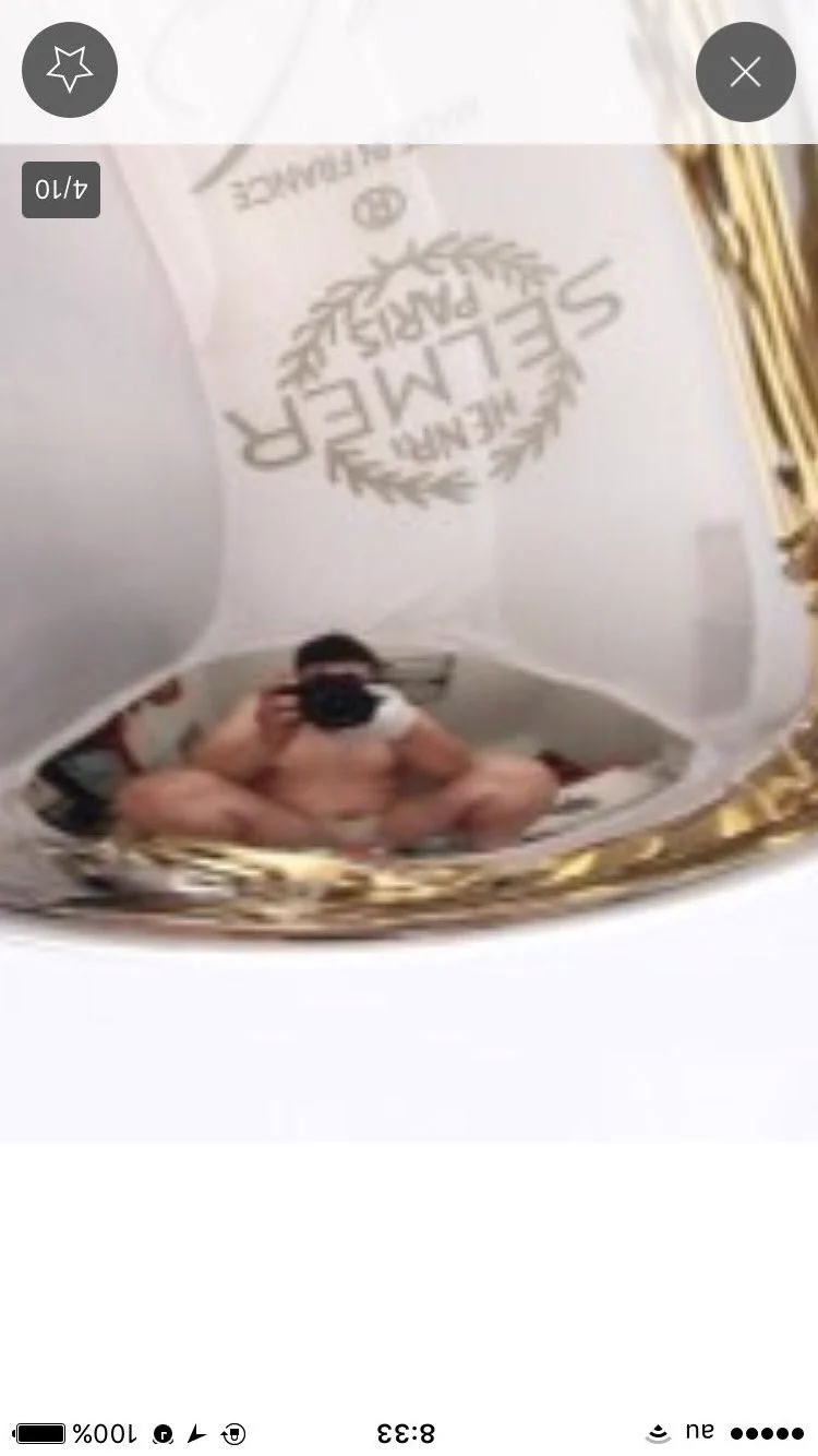 出品者の方は気をつけて。オークションに出したサックスに反射して写っていますよ。