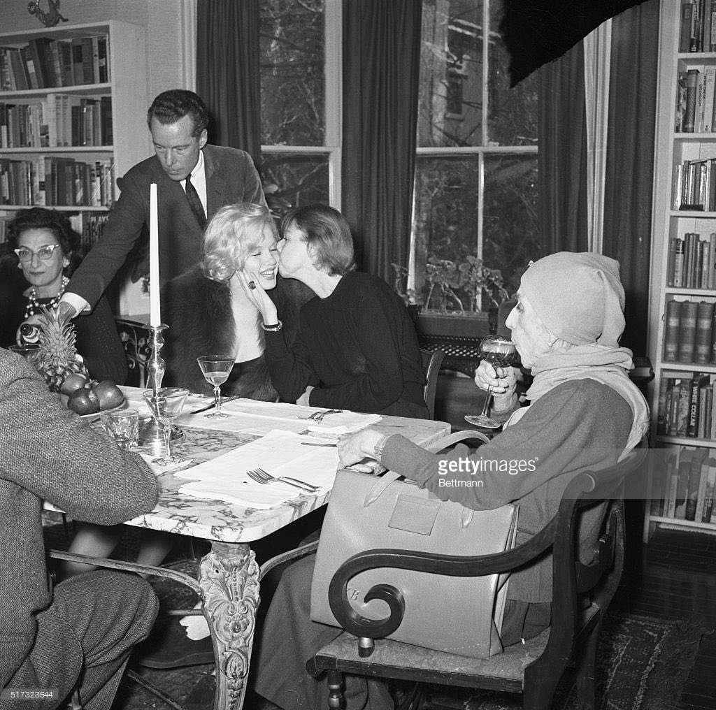 February 05, 1959: As famed Danish author Isak Dinesen (r) sips champagne, author Carson McCullers (center) gives Marilyn Monroe a kiss of greeting at Miss McCullers' home here, Feb. 5. The occasion was a luncheon given by Miss McCullers in honor of the Danish writer.