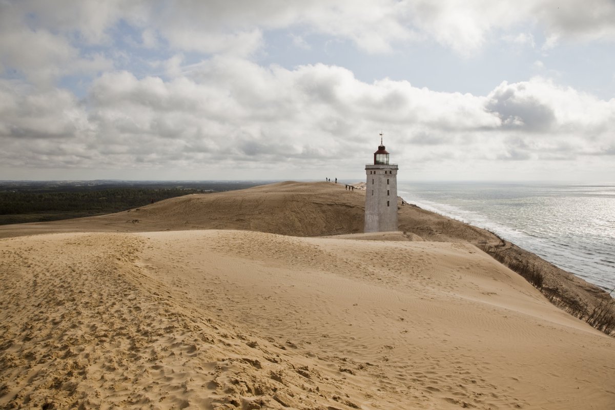 The lighthouse at Rubjerg Knude in Northern Denmark is slowly disappearing. Hurry up if you want to see it before it's swallowed by the nature! bit.ly/2DpcVqY Photo: Kim Wyon