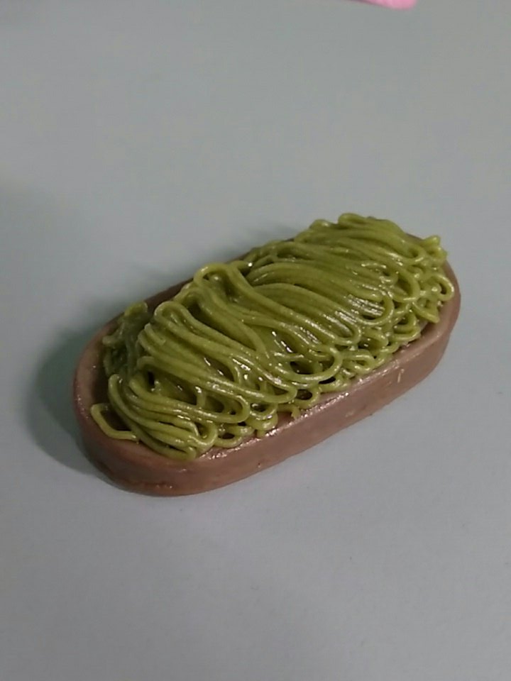 an oblong biscuit coated in chocolate on the bottom and a sort of gooey noodle on the top