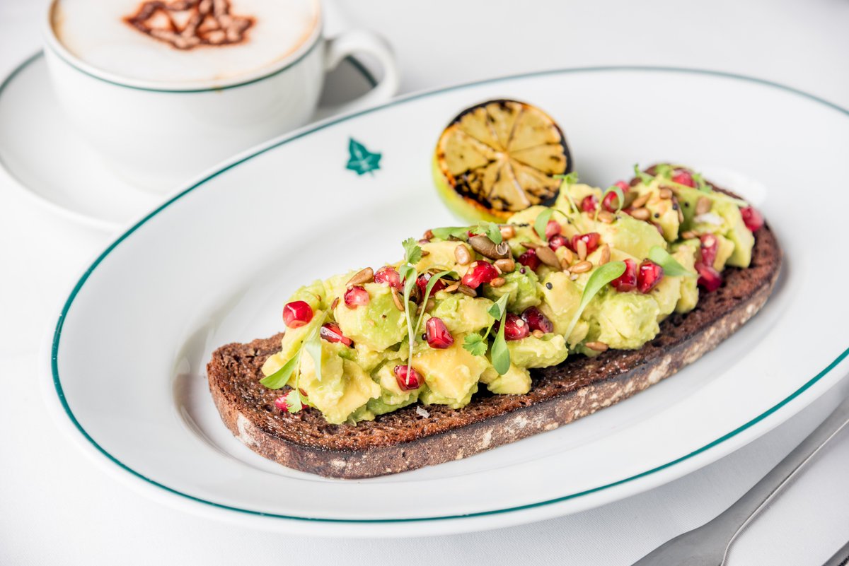 Healthy start to the morning: crushed avocado, lime and coriander with sunflower, pumpkin, linseed and pomegranate on dark caraway toast