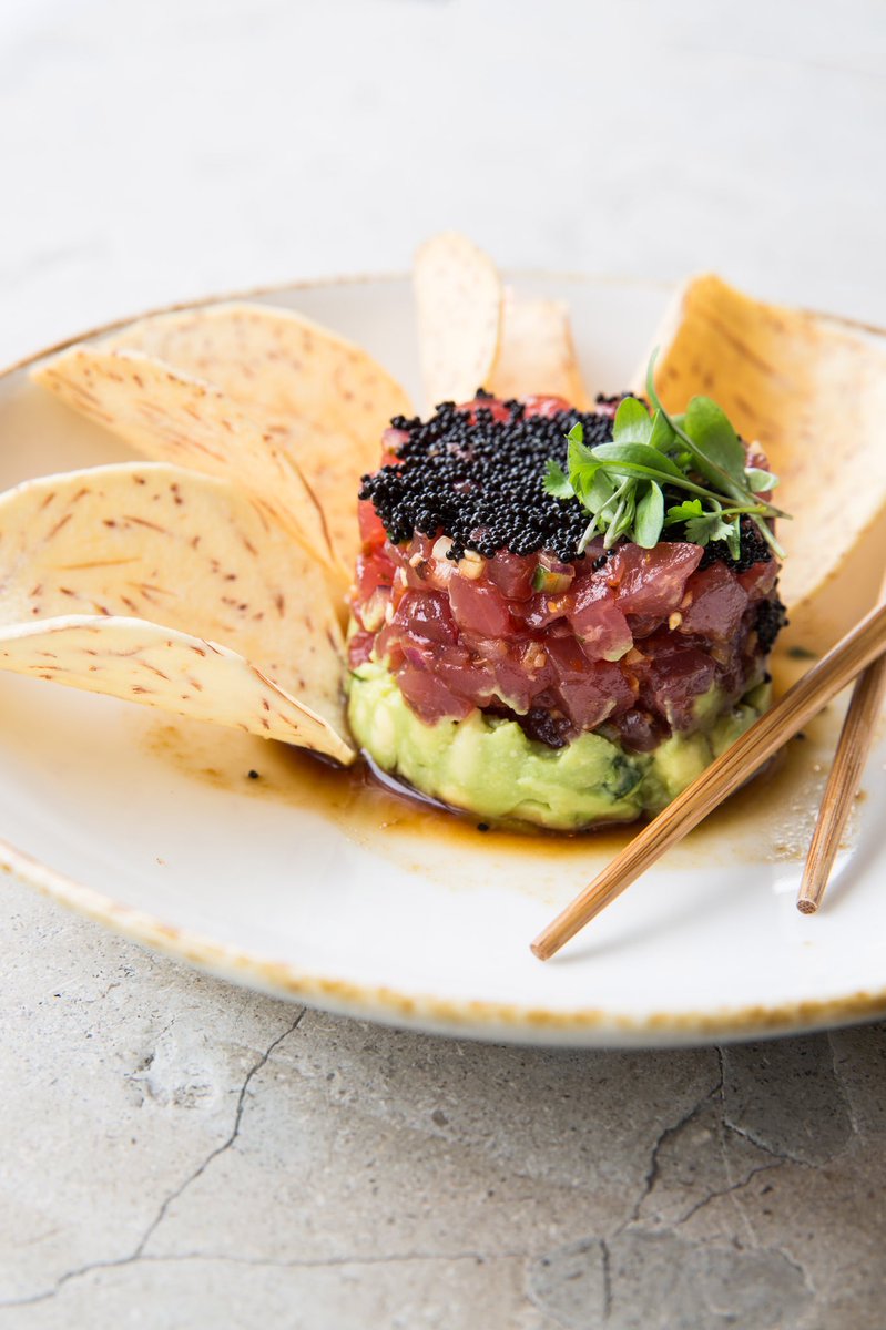 New to the menu- Our spicy yellowfin tuna tartare is layered with Hass avocado, sweet chili, cucumber, red shiso, and soy caviar, served alongside taro chips. How do you tartare? #lecolonialhouston #tunatartare