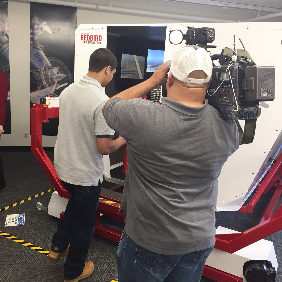 BHooverAcademy's tweet image. Student pilot Diego teaching #KSBW8 ‘s Lauren Seaver how to fly the #redbirdfmx flight simulator at the #bharibboncutting