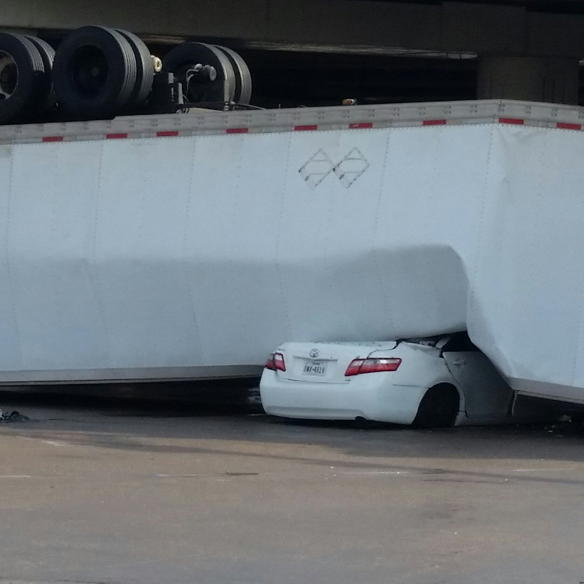 KPRC2's tweet photo. #BREAKING: Photos of 18-wheeler that drove off overpass at 59 SW Fwy south at University Blvd in Sugar Land. Driver of white car was rescued: https://t.co/gEJTtpdEX5 https://t.co/qYpMJITGca