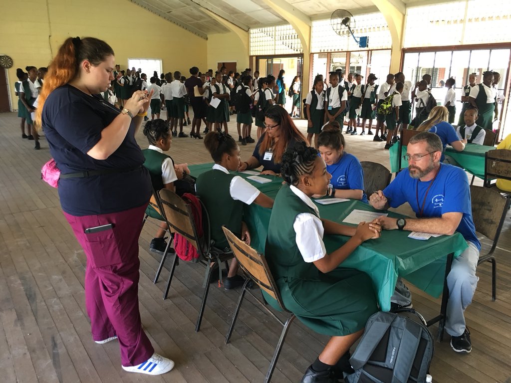 TXSTGlobalNews's tweet photo. A member of our team, @sjmctxst student Skyler Jennings, photographs respiratory therapy students while they screen high schoolers for asthma at Mackenzie High School in Linden, Guyana. #txst #studyabroad @StudyAbroadTXST @txst https://t.co/JiMJpzfXOA