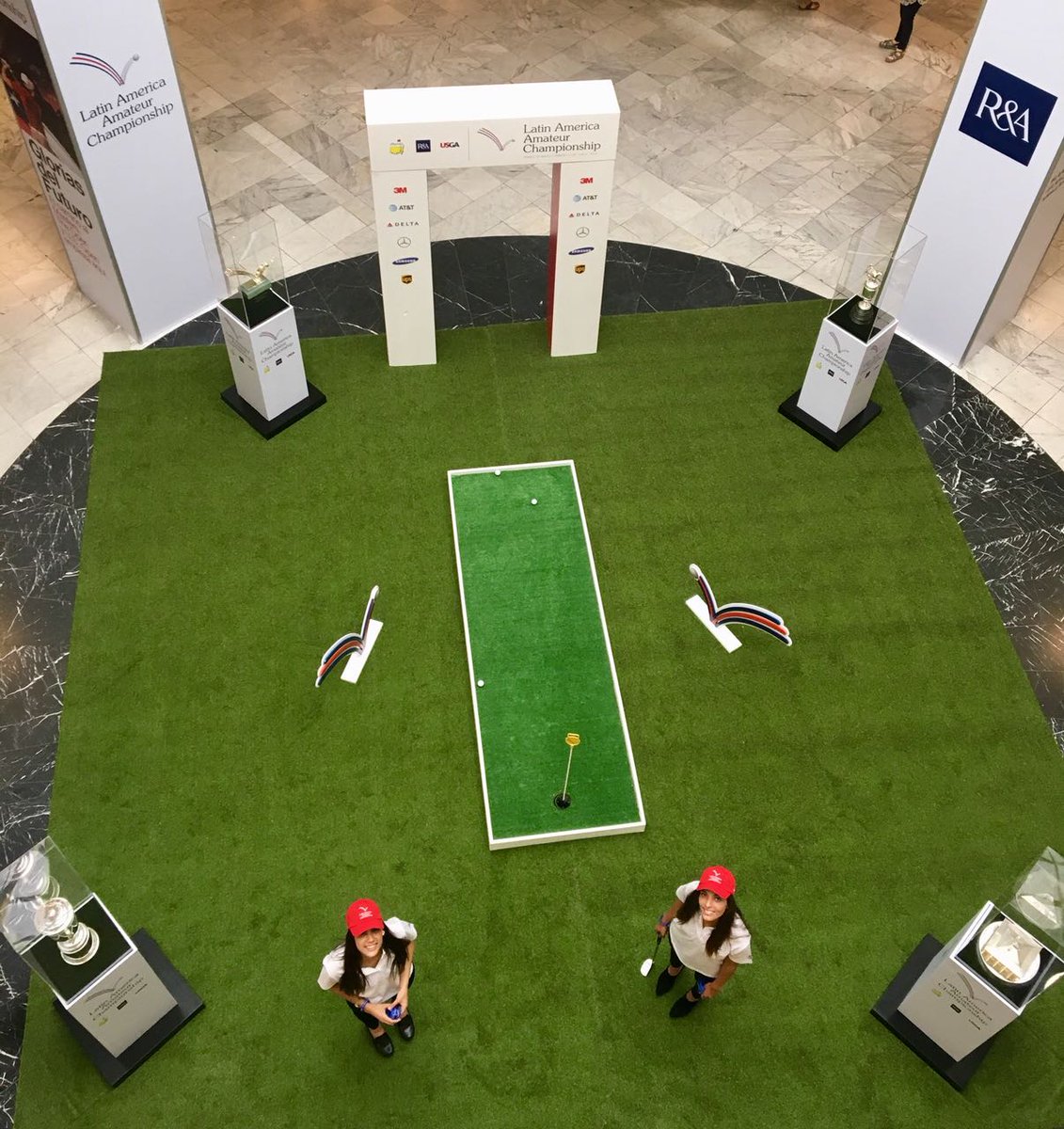LAAC_Golf's tweet photo. Quieres pegar algunos putts rodeado de los tres trofeos más importantes del golf mundial? Hoy y mañana ven al @ParqueArauco y llevate la pulsera oficial del torneo. Importantes premios para los mejores posteos en RRSS utilizando los hastags #LAAC2018 #GloriasdelFuturo https://t.co/6csqLZL2ey
