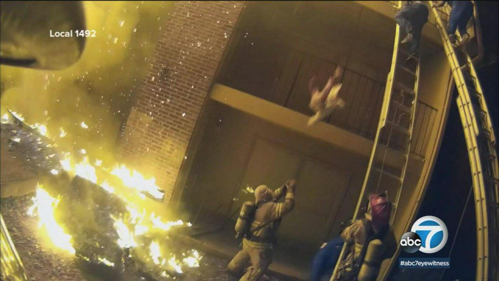 ABC7's tweet photo. HEROIC: Firefighter catches child from flaming balcony https://t.co/kaU6x3q0H9 https://t.co/wjeOGPvZxs